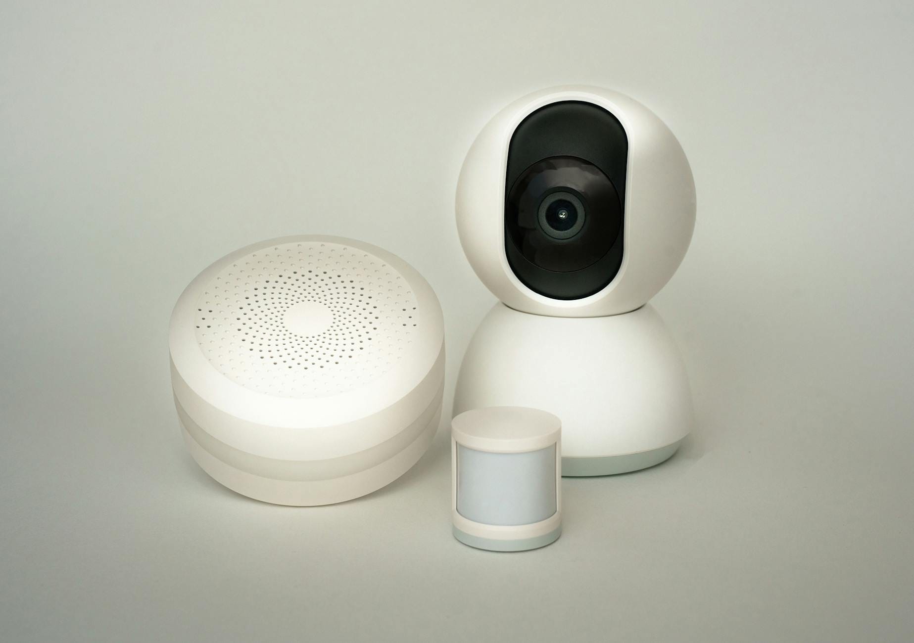 Smart home po polsku: nowe gadżety, które trzeba odpowiednio zabezpieczyć Kamera i czujniki inteligentnego domu na jasnym tle