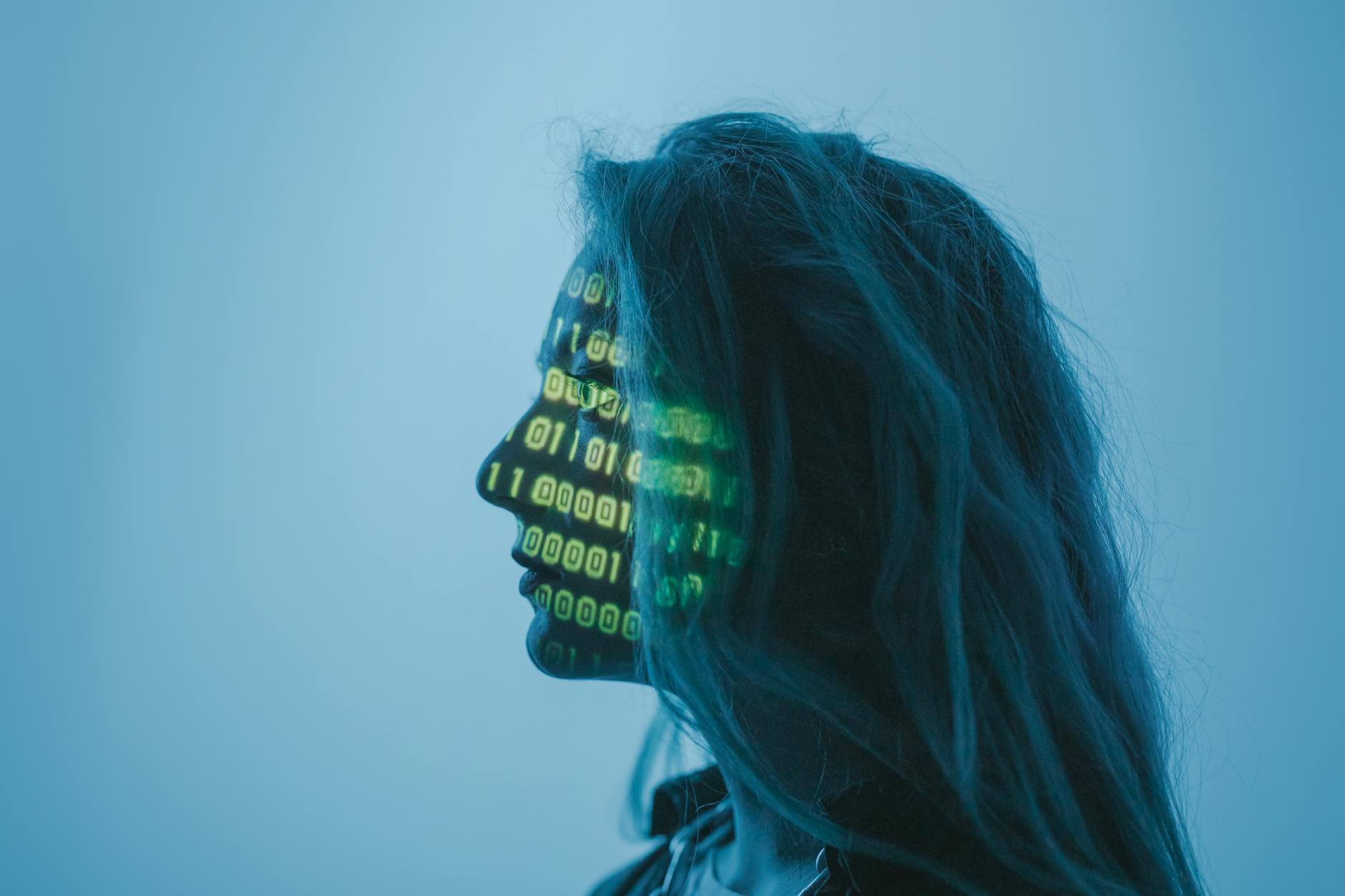 Sztuczna inteligencja w antywirusach: jak nowa technologia wykrywa zagrożenia Sylwetka kobiety z kodem binarnym na twarzy symbolizująca sztuczną inteligencję