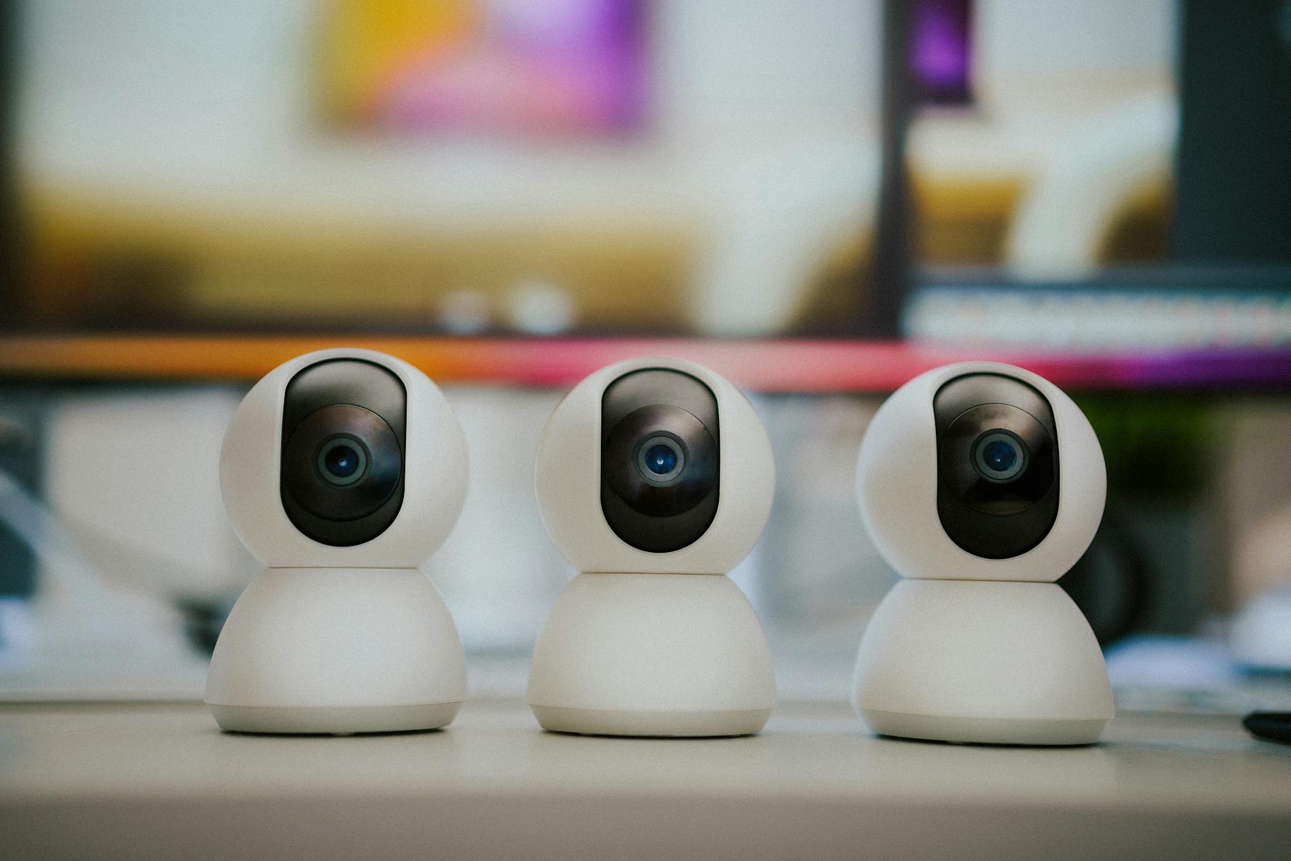 Trzy nowoczesne kamery smart home stojące na stole w mieszkaniu