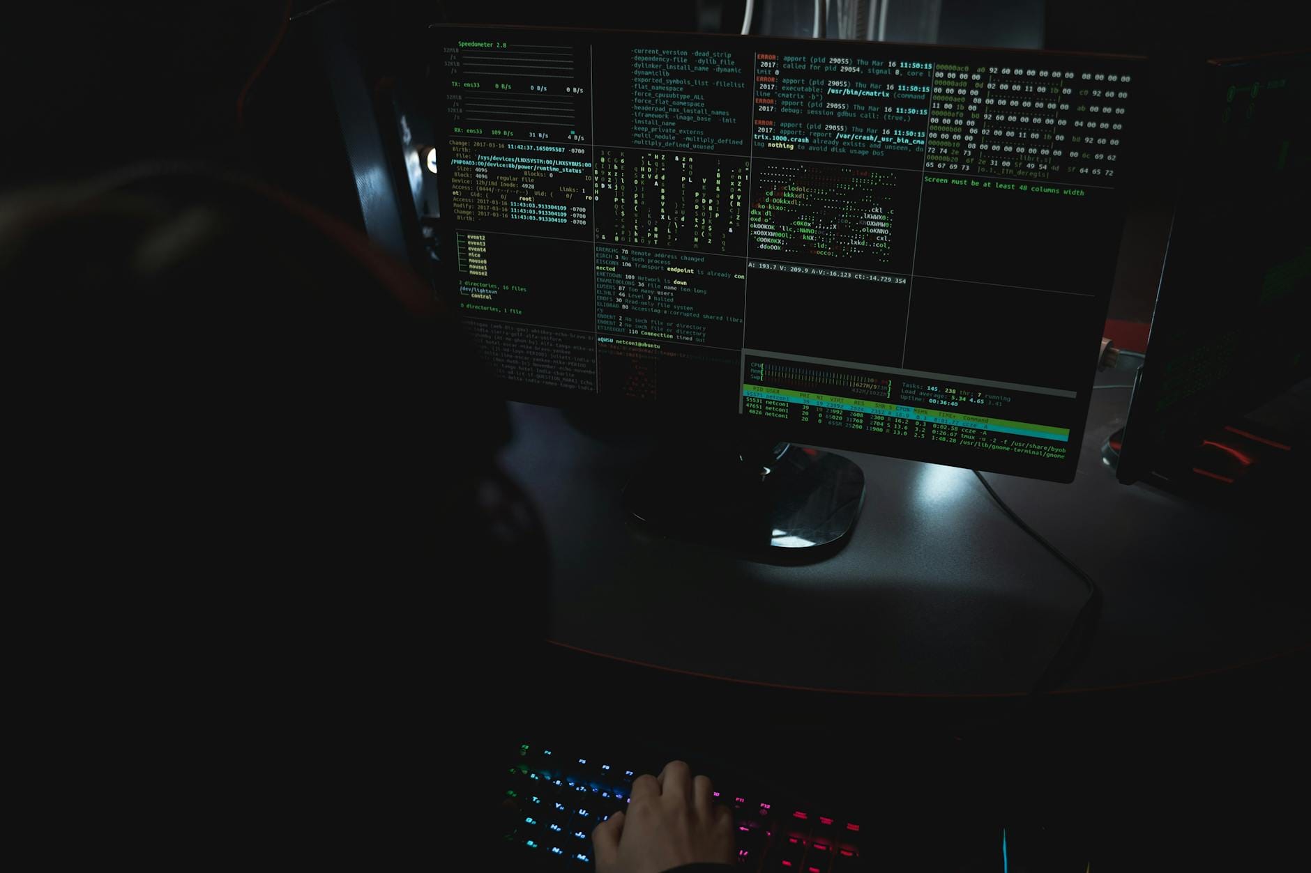 Ciemny pokój z monitorami wyświetlającymi kod i motywy cyberbezpieczeństwa