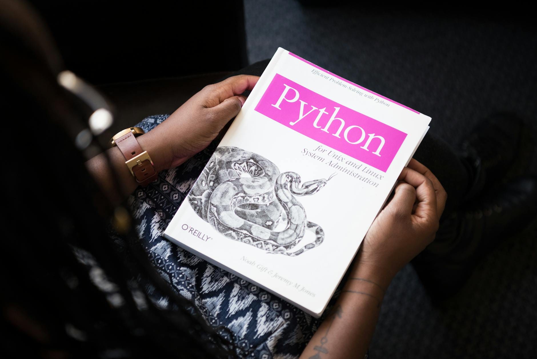 Osoba czyta książkę Python dla administracji systemów Linux i Unix