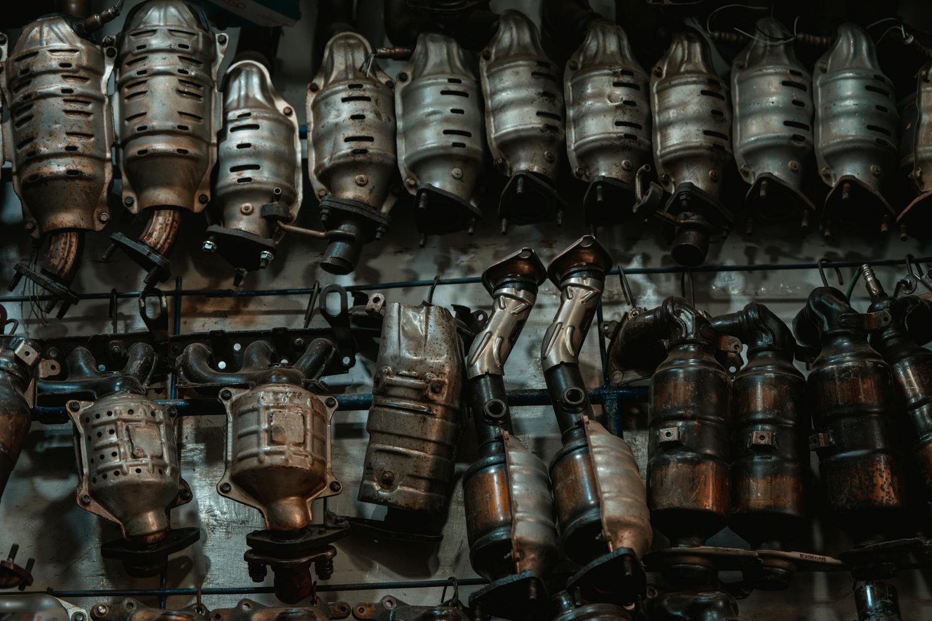 Jak wymienić katalizator w samochodzie krok po kroku – praktyczny poradnik dla kierowców Rzędy zużytych katalizatorów samochodowych w warsztacie mechanika