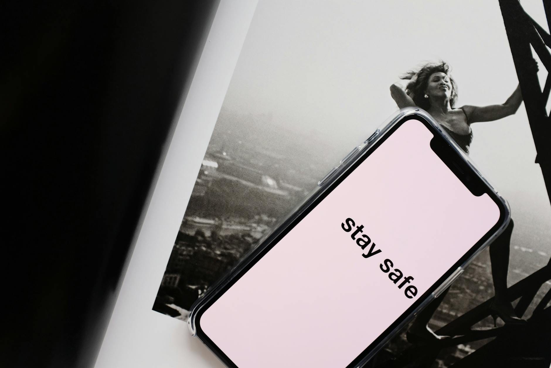 Instrukcja bezpiecznego korzystania z AI w pracy i domu: co wyłączać, czego nie wklejać i jak chronić dane Telefon z napisem STAY SAFE leżący na magazynie z kobietą na wieży