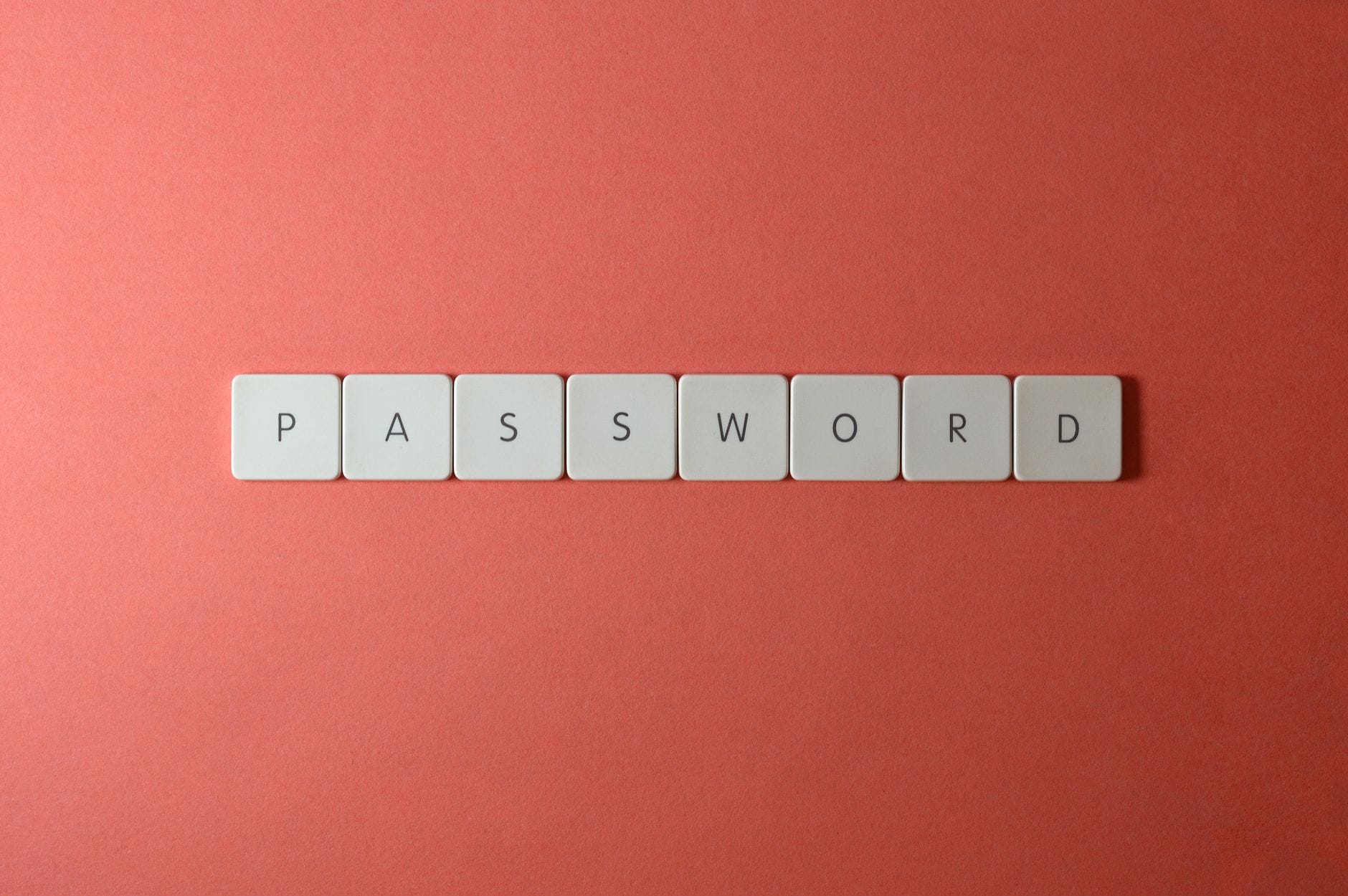 Hasła, loginy, dostęp: jak skutecznie zabezpieczyć konto do chmury przed włamaniem Białe klawisze z napisem PASSWORD na koralowym tle