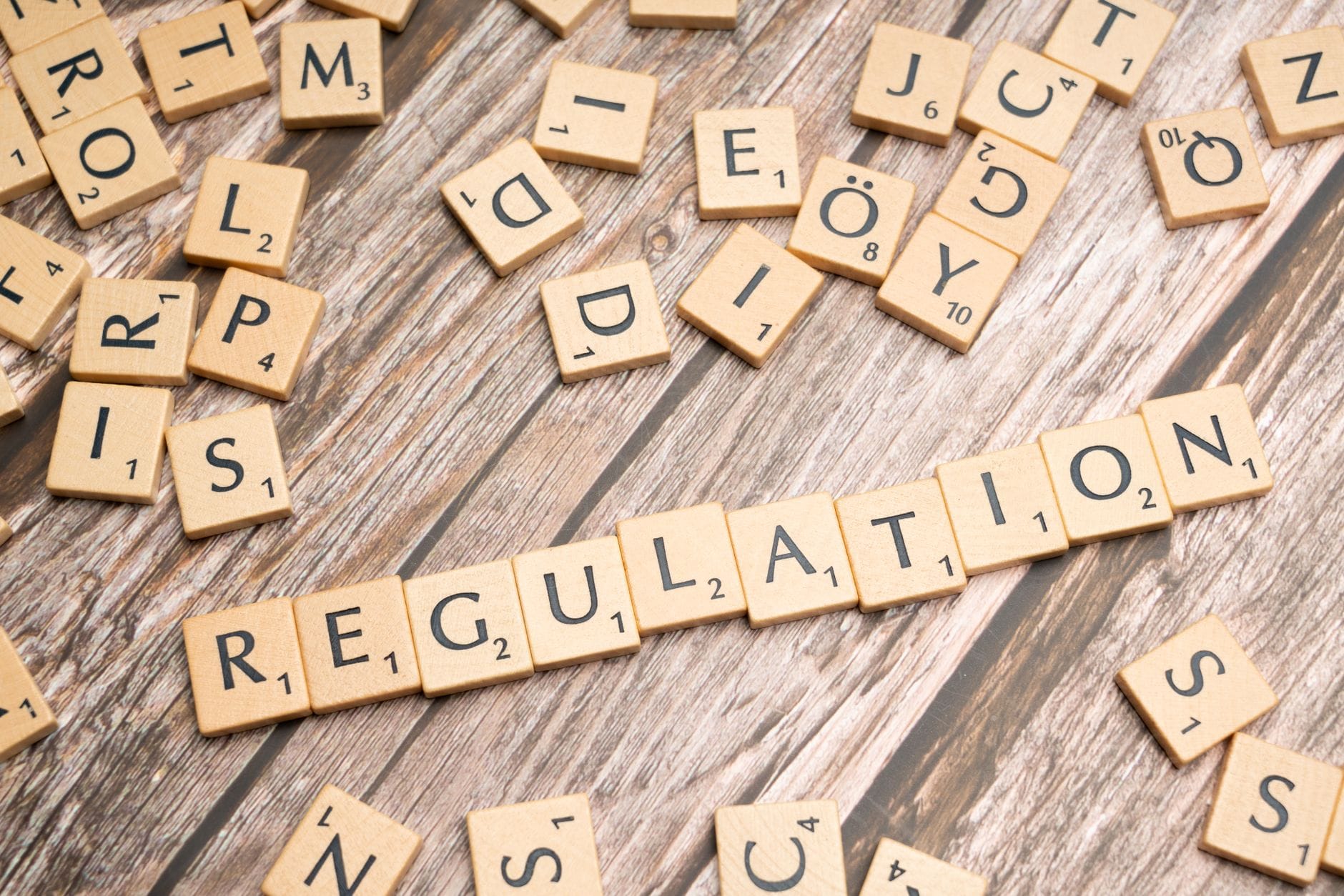 Drewniane kafelki z napisem Regulation na drewnianym tle