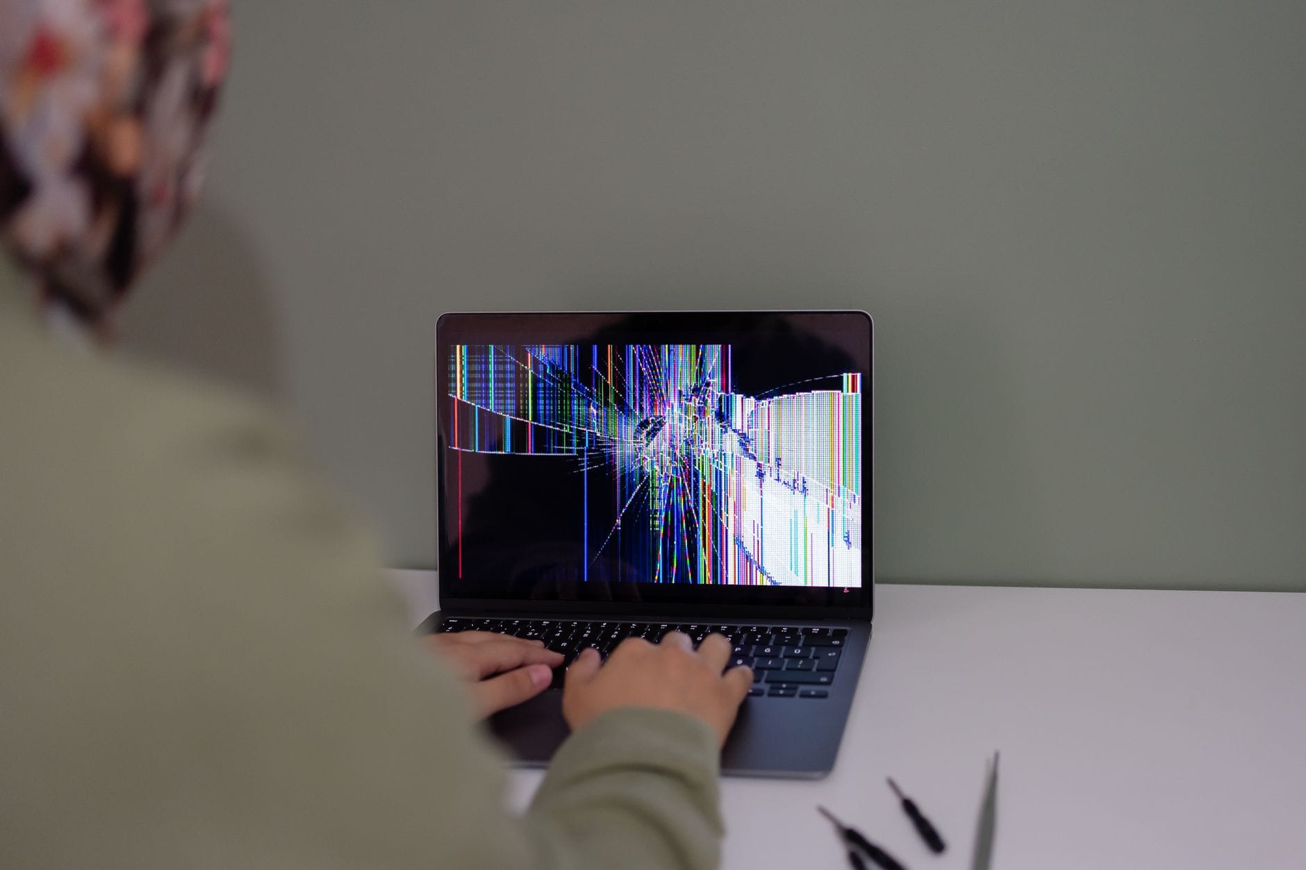 Osoba pracująca na laptopie z pękniętą matrycą Osoba pracująca na laptopie z pękniętą matrycą