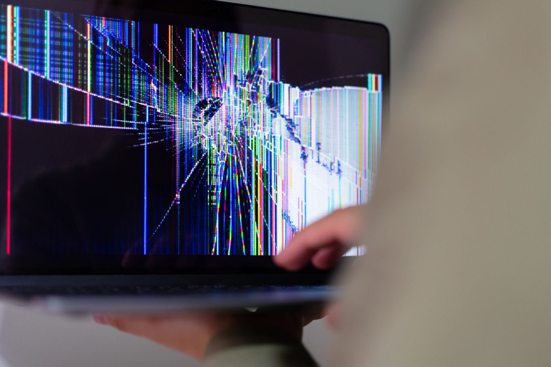 Pęknięty ekran laptopa z kolorowymi zniekształceniami obrazu