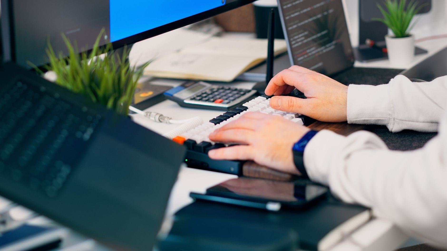 Praca przy klawiaturze w nowoczesnym biurze z komputerem i sprzętem tech