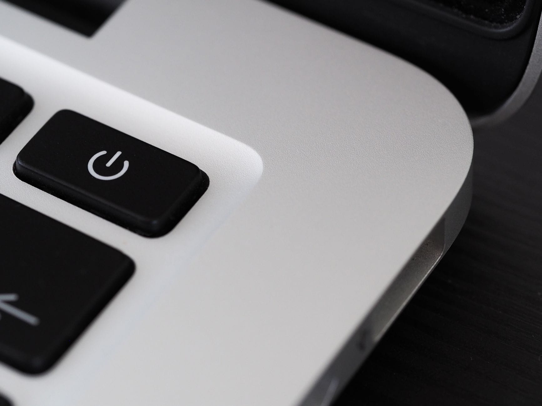 Zbliżenie przycisku zasilania na nowoczesnym, smukłym laptopie