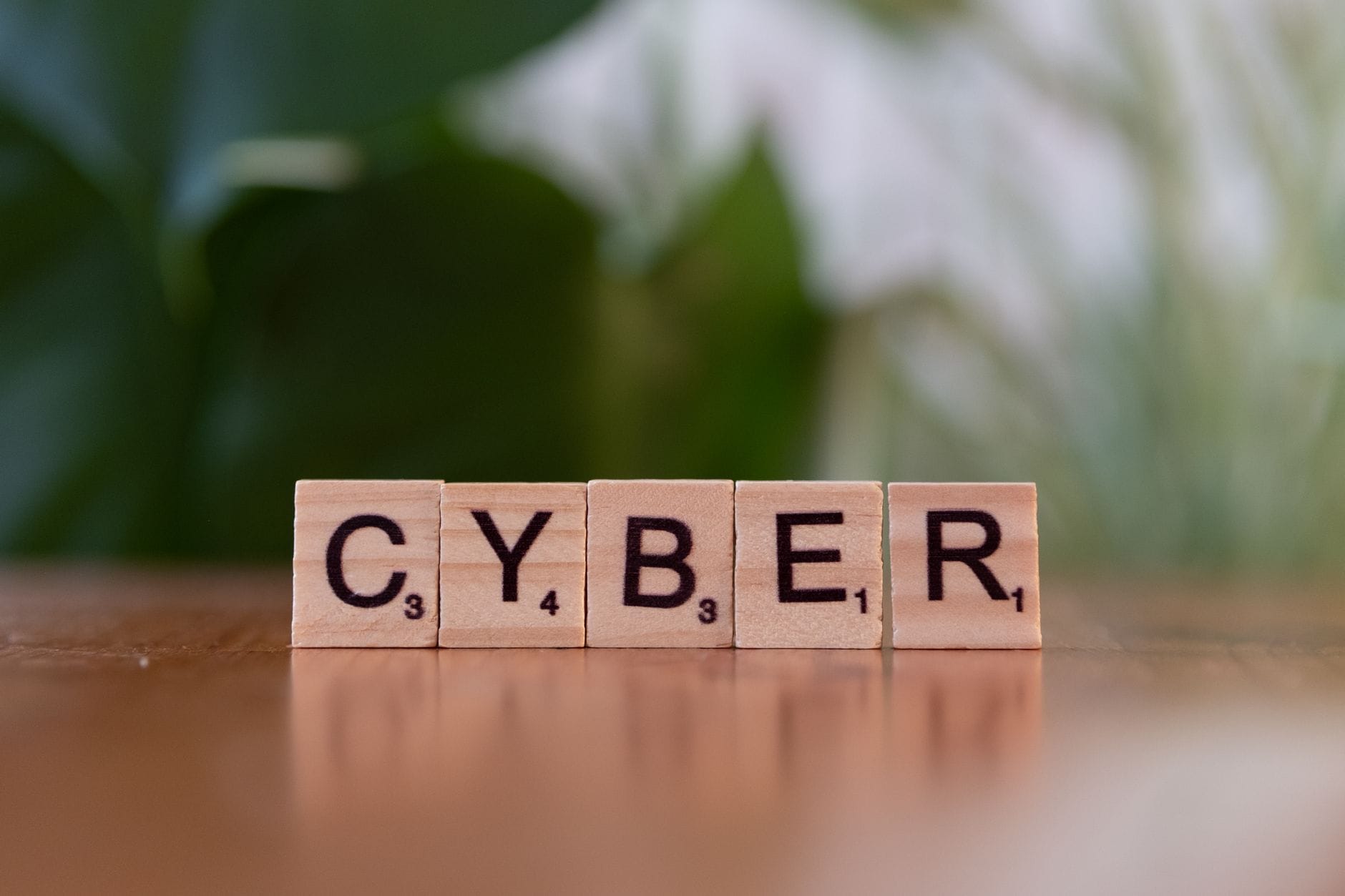 Drewniane kostki z napisem CYBER na rozmytym tle nawiązujące do cyberbezpieczeńs Drewniane kostki z napisem CYBER na rozmytym tle nawiązujące do cyberbezpieczeńs