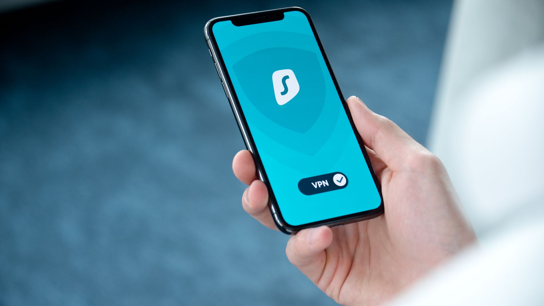 Dłoń trzyma smartfon z aplikacją VPN na ekranie do bezpiecznego surfowania