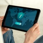 Co widzi Twój dostawca internetu, gdy używasz VPN, a co, gdy z niego rezygnujesz Osoba trzyma tablet z ekranem połączenia VPN do bezpiecznego internetu