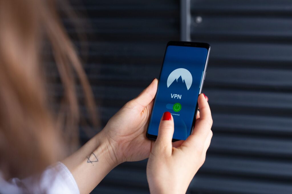 Kobiece dłonie korzystające z aplikacji VPN na smartfonie
